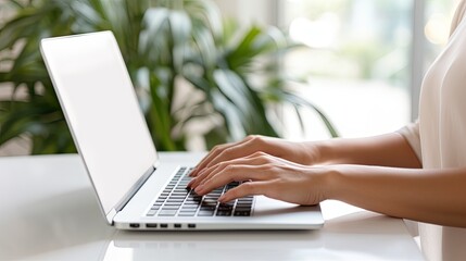 Woman freelancer working on laptop in her two level living room with white blank screen Mock up copy space available . Mockup image