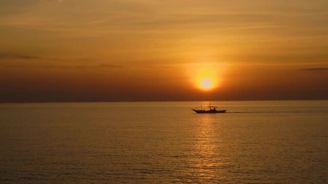 A fishing boat passes by in the early morning light.