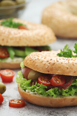 Sesame bagels with tomatoes, ham and olives