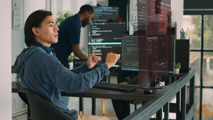 Trained developers helped by AR technology to visualize script in multiethnic office, writing code lines on computer using Java programming languages. Coworkers securing company data