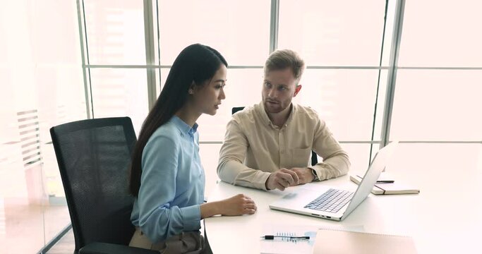 Confident financial consultant adviser talk to client, explain commercial investment deal, show presentation on computer at formal meeting. Colleagues work together, learn new software. Apprenticeship