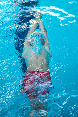 Swimmer boy swims backstroke swimming style in the pool - 637805797
