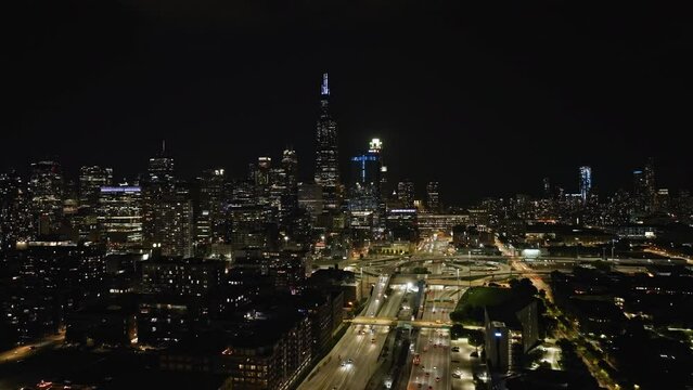 Aerial tracking shot over the West loop and the illuminated Chicago skyline, in Il, USA