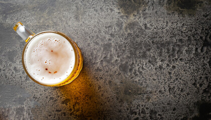 Beer in a glass on a old stone surface. Top view