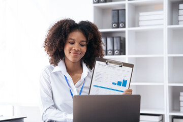 Businesswomen hand working with tablet and laptop computer with documents on office desk in modern office.