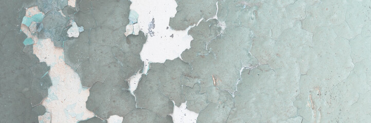 Green peeling paint on the wall. Old concrete wall with cracked flaking paint. Weathered rough...