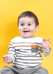 Bebé gracioso con fondo amarillo sonriendo