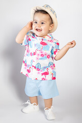 Bebé sonriente vestido a la moda con camisa de flamencos y gorro. Concepto moda de bebé