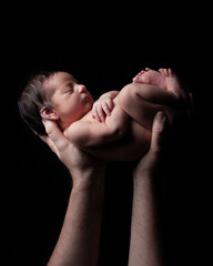 Padre sujetando bebé recién nacido, concepto paternidad, fondo negro