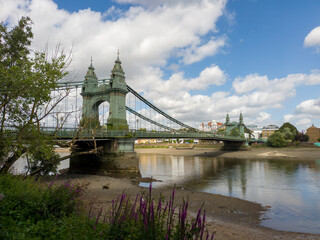 Fototapeta na wymiar Hammersmith Bridge viewed from the south bank of the River Thames in West London, UK