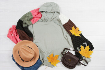 Close up mint green blank template autumn fall sweatshirt hoodie with copy space. Autumn yellow leaf. Top view mockup sweatshirt pullover, white wooden background. Casual Shirt outfit. Flat lay wear