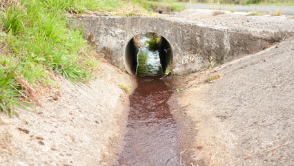 Agua bajo tunel de desagüe junto a camino