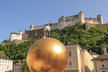 Salzburg; Blickfang auf dem Kapitelplatz, Skulptur Sphaera vor der Festung Hohensalzburg - obrazy, fototapety, plakaty