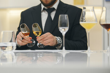 Sommelier looking at color of drink during alcohol beverages training. Training of restaurant...