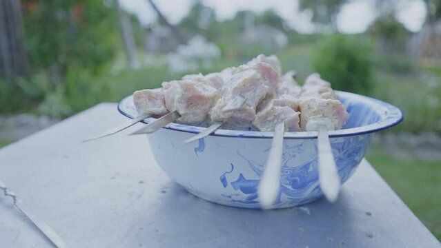 Marinated juicy meat strung on skewers for barbecue prepared for party in garden. Prepared pork strung on skewers waits to be barbequed on grill