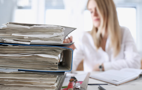 Lot of work wait for tired and exhausted woman. Huge pile of document folders headache and depression irs new problems emotion expression vacancy or holiday dream concept