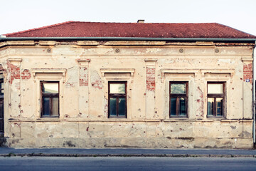 Residental building facade heavily damaged in the Balkans war. Window with bullet hole on war.