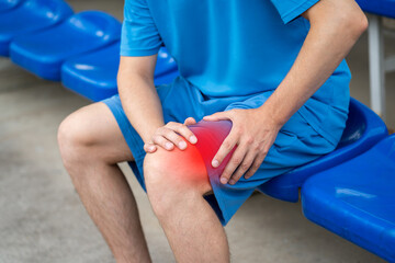 Diseases of the knee joint, bone fracture and inflammation, athletic man on a sports ground after...