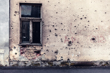Damaged building in Ukraine war. Historic war damage, bullet holes in residential building. - obrazy, fototapety, plakaty