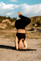 Woman doing yoga and standing on nails in the desert at sunset.The concept of yoga and standing on nails