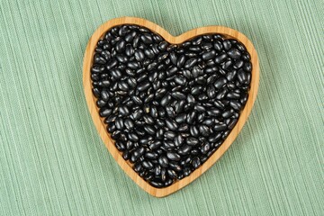 heart shaped black bean bowl on green tablecloth