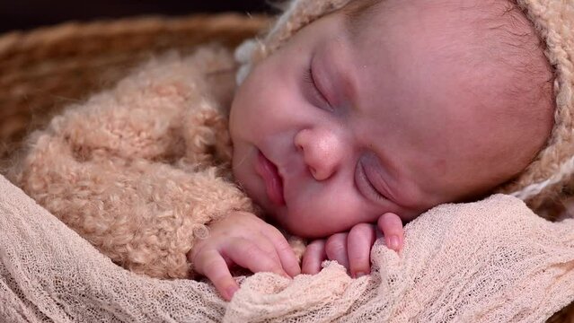 Sleeping newborn beautiful cute baby girl or boy before photo session during first week of life. 4k slow motion raw video. Happy Family concept. Small baby at wicker basket sleep in warm lamb costume