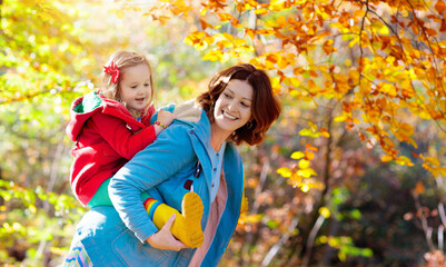 Mother and kid in autumn. Fall outdoor family fun. - Powered by Adobe