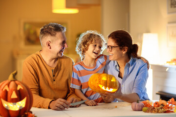 Family carving pumpkin. Halloween trick or treat