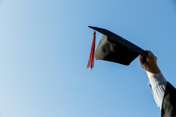 Mantle and hat in female hand against the sky, space for text