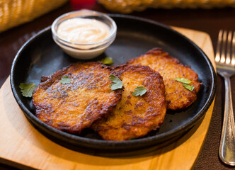 Belarusian cuisine. Appetizing potato draniki stew with sour cream