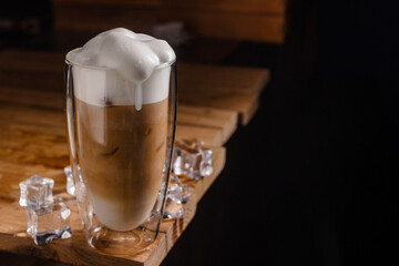 coffee drink with cream and ice on a dark wooden background