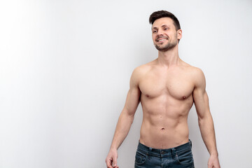 Portrait of shirtless attractive cheerful sportive young man. Isolated over light grey background