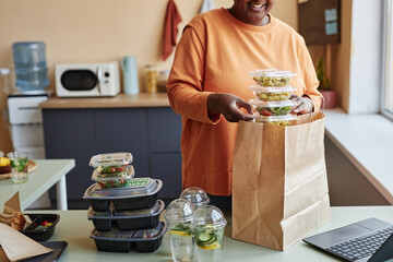 Cropped shot of black woman unpacking food delivery order at home, copy space