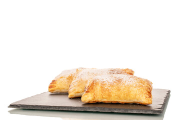 Three aromatic puff pastry buns with apples on slate stone, macro, isolated on white background.