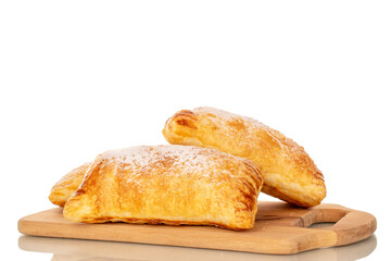 Two aromatic puff pastry buns with apples on a wooden kitchen board, close-up, isolated on white...