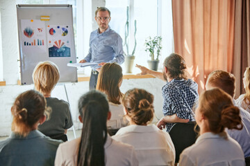 Male leader giving at business meeting performing presentation. Audience in conference hall. Business and entrepreneurship symposium.