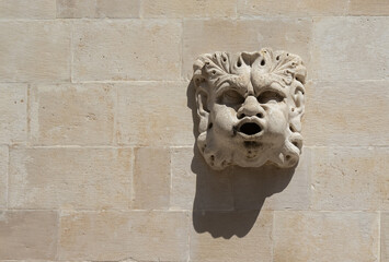 The face protrudes from the white stone wall. Background with copy space. Dubrovnik Croatia....