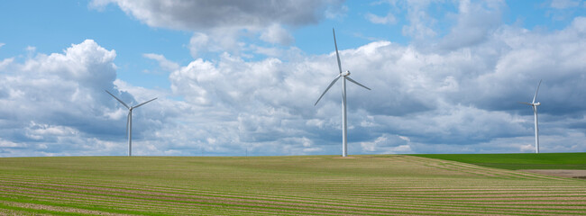 almost abstract fields in countryside of northern france with wind turbines