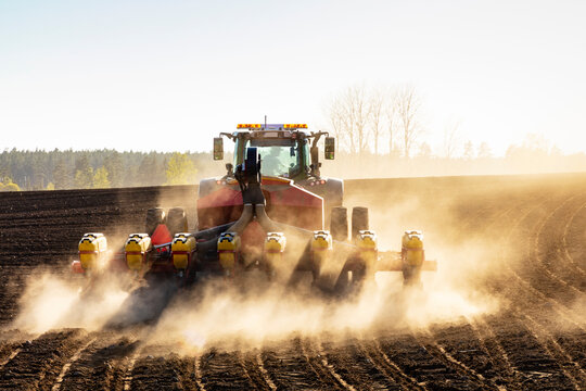 Tractor Plowing Field At Sunny Day