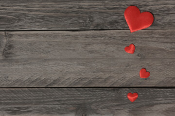 Red hearts in a row on wooden background.