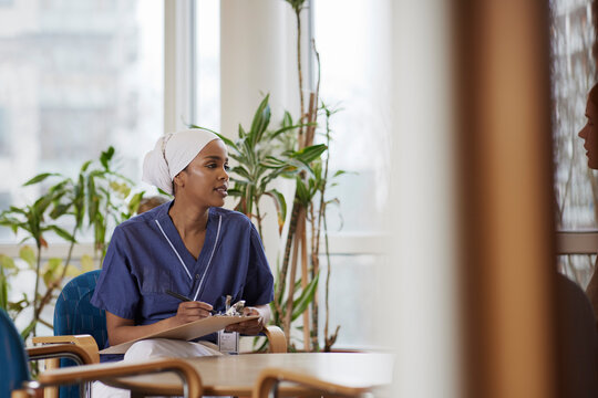 Female doctor looking away and taking notes