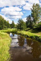 Beautiful summer river at sunny day with clouds reflection in the water
