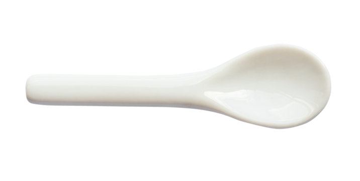 top view of little white ceramic spoon cutout on white background