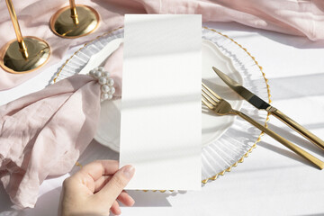 4x9 menu card mockup in hand with golden accessories