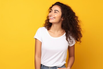 happy smiling female wearing plain white t-shirt for mock up on yellow background