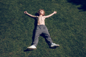 Shirtless boy relaxing on green lawn © ADDICTIVE STOCK CORE