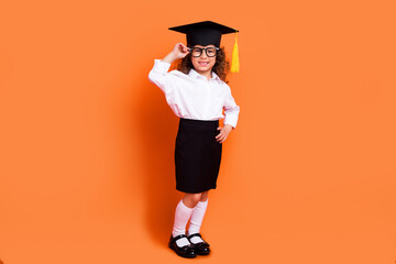 Photo of little smart schoolgirl professor graduate school wear mortarboard hat isolated bright color background