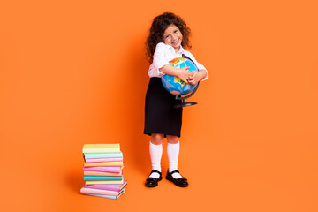 Photo of sweet school kid girl hold globe earth enjoy learning in classroom courses isolated shine color background