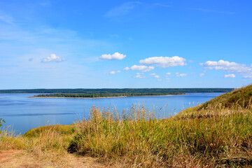 blue river with island and blue sky with clouds view from top of the hill copy space   