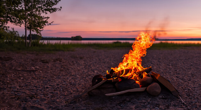 beautiful campfire made of firewood in the middle of a beach with a beautiful sunset in high resolution and sharpness